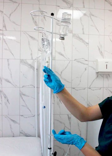 Врач поправляет капельницу